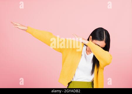 Asian felice ritratto bello cute giovane donna teen sorriso in piedi muoversi mostrando DAB danza contro gesto sollevare le mani braccia coprendo faccia isolata, s. Foto Stock