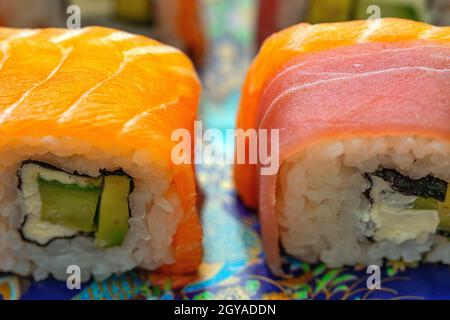 Sushi californiano con avocado, cetriolo e formaggio avvolto in salmone e tonno Foto Stock