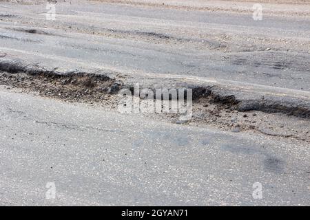 Postolo sulla strada da autocarri pesanti. Distruzione di asfalto da auto sovraccaricate. Foto Stock