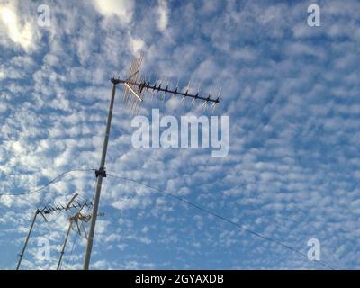 Antenne TV domestiche su cielo blu nuvoloso. Messa a fuoco selettiva Foto Stock