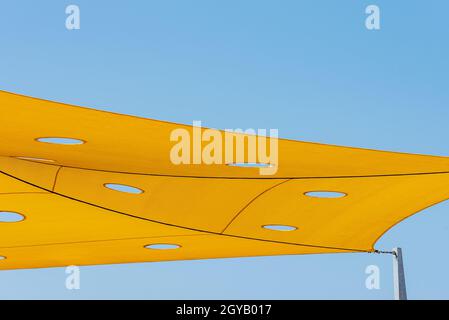 Tessuti per coprire il sole e fare ombre, con forme triangolari. Tessuto stirato protezione solare Foto Stock