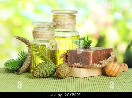 Fatte a mano sapone e bottiglie di abete olio sul tappetino di bambù Foto Stock