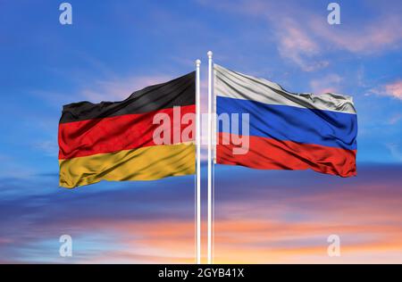 Germania e Russia due bandiere su paletti e blu nuvoloso cielo Foto Stock