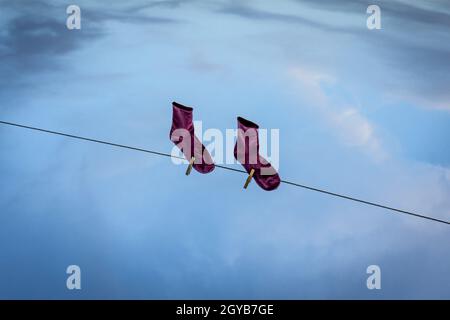 Riflesso di un paio di calze viola appese su una linea di biancheria sull'acqua Foto Stock