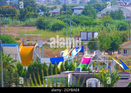 Scivoli colorati e giocattoli di un piccolo parco acquatico di un piccolo complesso di edifici ad Antalya Foto Stock