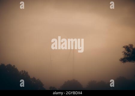 Paesaggio con turbine eoliche nella nebbia Foto Stock