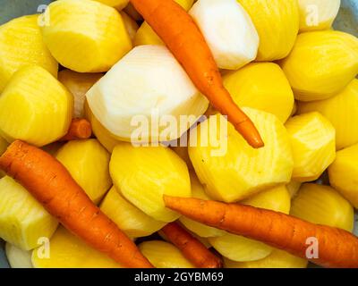 Verdure patate e carote sono lucidate per cucinare. Cibo foto. Raccolta di verdure. Foto pubblicitaria di una vetrina di un negozio di verdure. Foto Stock