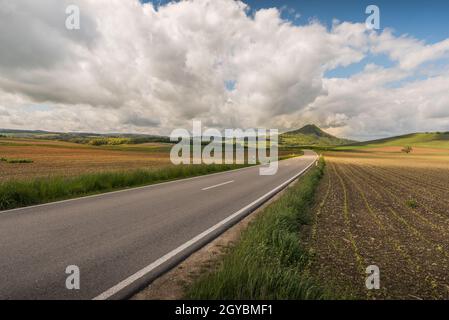 Strada di campagna nel paesaggio vulcanico Hegau con vista sul Hohenhewen, quartiere di Costanza, Baden-Wuerttemberg, Germania Foto Stock