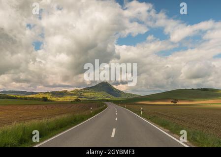 Strada di campagna nel paesaggio vulcanico Hegau con vista sul Hohenhewen, quartiere di Costanza, Baden-Wuerttemberg, Germania Foto Stock