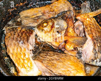 La carpa crogiolante di pesce viene fritta in una padella. Carpa crogiana di pesce d'acqua dolce. Menu di piatti. Pesca cattura. Cucina cibo. Cucina domestica. Inserire il testo. Bac Foto Stock