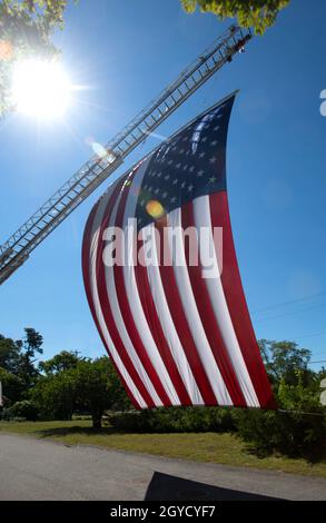 La bandiera americana vola di fronte alla stazione dei vigili del fuoco a Wellfleet, Massachusetts, USA l'11 settembre Foto Stock