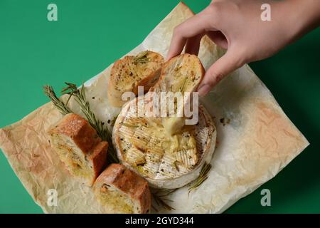 Camembert al forno con toast , rosmarino su carta da cucina bianca Foto Stock