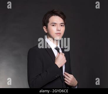 Giovane asiatico bel Business uomo in abito nero Foto Stock