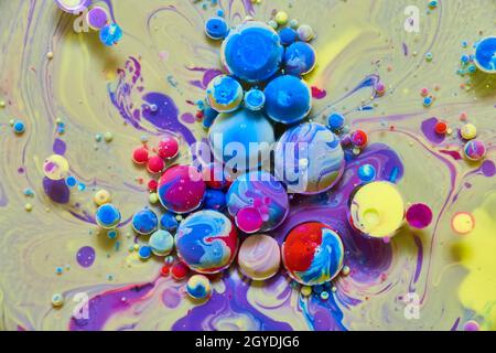 Superficie setosa gialla e viola con orb arcobaleno colorati Foto Stock