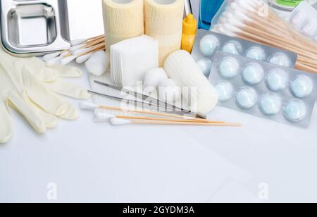 Set di medicazioni per la cura delle ferite. Pinzette, bastone di cotone, bendaggio conforme, bendaggio elastico di ritenzione coesiva, batuffolo di cotone con alcool, guanti monouso in lattice Foto Stock