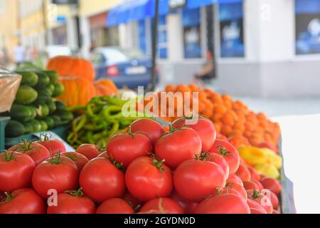 Pomodori e altri frutti e ortaggi in vendita presso il mercato agricolo locale. Prodotti biologici freschi in vendita presso il mercato agricolo locale. Foto Stock