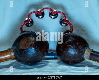 maracas e tamburello posti su uno sfondo che è un tessuto bianco con illuminazione bluastra. Foto di alta qualità Foto Stock