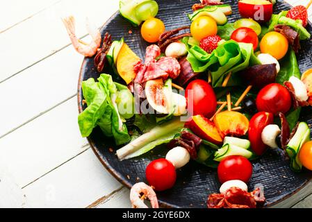 Antipasto a buffet di gamberi, jamon, frutta e verdura su spiedini di legno Foto Stock