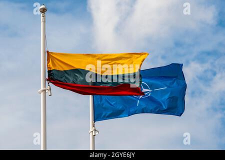 Bandiera lituana e bandiera NATO che sventolano nel vento contro lo sfondo del cielo Foto Stock