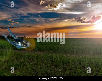 UFO atterraggio su un campo agricolo nei raggi di un tramonto. Oggetto volante non identificato. Veicolo spaziale volante. Invasione aliena. Civiltà aliena. Centro benessere Foto Stock