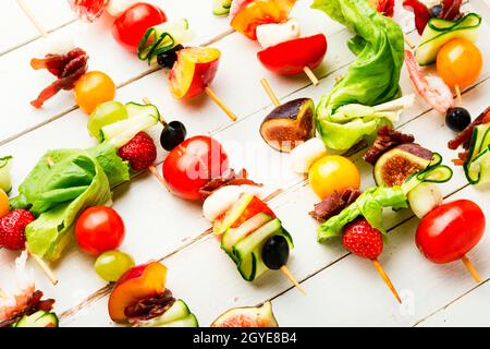 Antipasto a buffet di gamberi, jamon, frutta e verdura su spiedini di legno Foto Stock