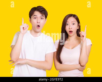 Giovane coppia puntando le dita insieme isolato su sfondo giallo Foto Stock