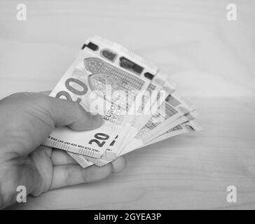 Tenuta a mano banconote in euro (EUR), valuta dell'Unione europea in bianco e nero Foto Stock