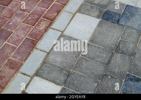 Calcestruzzo o pavimentazioni pavimentate di recente posa in grigio e rosso o pietre per pavimenti o passerelle. Lastre per pavimentazione in calcestruzzo nel cortile o nella pavimentazione stradale. Giardino Foto Stock