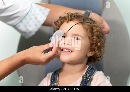 Bambina con una patch a una consultazione optometristo Foto Stock