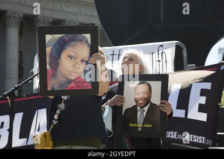 Le vite nere contano la dimostrazione a NYC con il messaggio, 'uccidere le persone nere' non solo attraverso le sparatorie della polizia, ma le politiche economiche che influenzano le comunità più povere. Donna tiene foto di Breonna Taylor tra gli altri inutilmente sparato e ucciso dalla polizia. Foto Stock