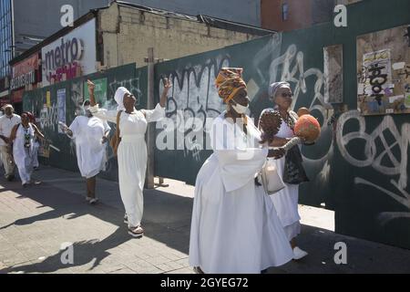 Il gruppo partecipa a una passeggiata Africana Healing intorno ad Harlem durante il giorno del festival African Heritage qui visto diretto verso l'up125th Street al Adam Clayton Powell NY state Building per African Square. Foto Stock