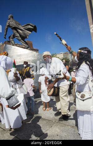 Il gruppo partecipa a una passeggiata Africana Healing intorno ad Harlem durante il giorno del festival African Heritage qui visto da 125th Street al Adam Clayton Powell NY state Building a African Square. Foto Stock