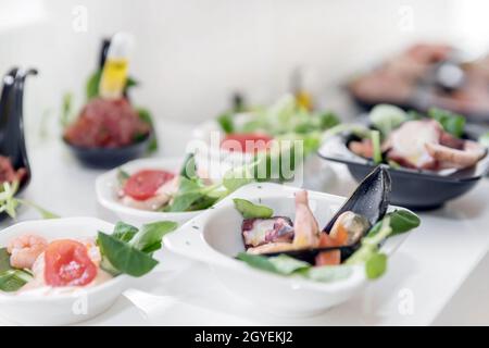 Spuntini leggeri di pesce su un tavolo a buffet. Mini-veloce assortito, delicatezze e spuntini, ristorante di pesce all'evento. Festa di nozze. Ricevimento di gala. Decora Foto Stock