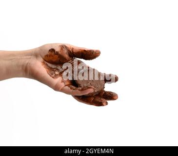 mano femminile che tiene un pezzo fuso di cioccolato fondente, a mano cosparsa di cioccolato su fondo bianco Foto Stock