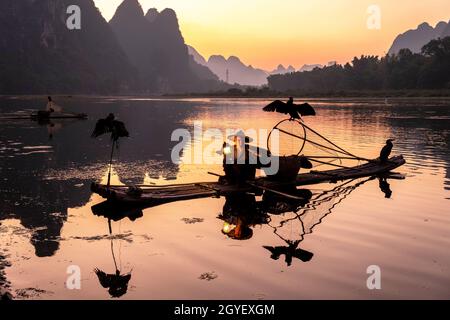 Villager vestito da pescatore cormorano a Xingping, Cina Foto Stock