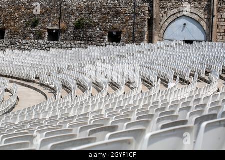 L'auditorium vuoto con sedie in plastica grigia in un antico anfiteatro Foto Stock