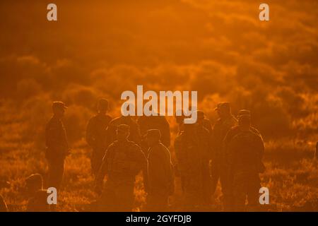 I soldati della Guardia Nazionale dell'Esercito Idaho della Charlie Company si ergono sulla collina della 4° zona dell'Orchard Combat Training Center mentre il sole sorge dietro di loro. La Charlie Company della Guardia Nazionale dell'Esercito Idaho del 2-116th Combined Arms Battaglione è tornato sul campo per la perforazione di ottobre sul Orchard Combat Training Center. L'allenamento si è concentrato sull'uso di armi DA serbatoio anti AT-4, il lanciagranate M320, la familiarizzazione con gli esplosivi in plastica C4, le miniere di Claymore e la formazione GREM (Grenade Rifle Entry Munition). A completare il fine settimana sono stati gli esercizi di navigazione terrestre e un marc mattinata di cazzo Foto Stock