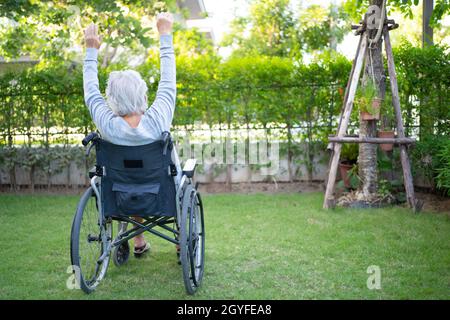 Asian anziano o anziano donna anziana esercizio paziente su sedia a rotelle con felice fresco godere in giardino di casa, sano forte concetto medico Foto Stock