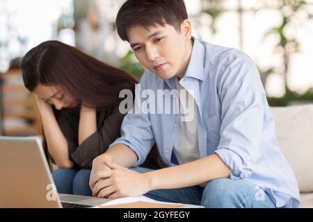 coppia stressata usando il laptop a casa. Foto Stock