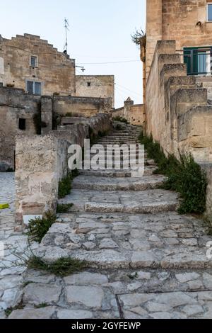 Matera, Italia - 15 settembre 2019: Tipiche scale acciottolate in un vicolo laterale della strada, nei Sassi di Matera, un quartiere storico della città di Matera Foto Stock