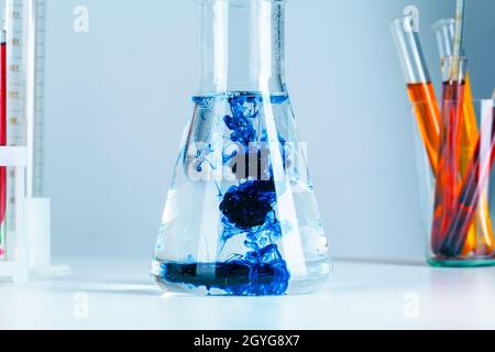 Vetreria per matracci da laboratorio con riflessi a primo piano sul tavolo Foto Stock