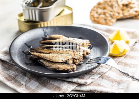 Spratti affumicati su piastra. Pesce di mare in scatola. Foto Stock