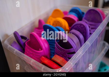 Sandali in gomma colorati e confortevoli realizzati in gomma per la vendita nella zona del mercato locale. File di belle pantofole multicolore Foto Stock