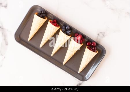 Cono di cialda con ribes surgelati bacche isolati su sfondo bianco, concetto di succosa gelato, close up Foto Stock