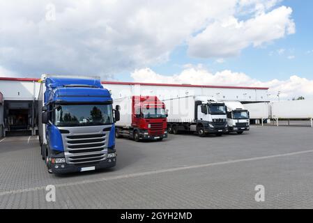 Camion che caricano ad un deposito di un'agenzia di spedizione - Trasporti e logistica nel commercio di merci Foto Stock