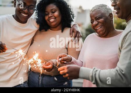 Happy Black Family festeggia con gli sparklers all'aperto a casa - Focus on Mother Face Foto Stock