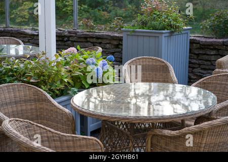 Accogliente terrazza all'aperto al ristorante, caffè o hotel nel giardino della città, parco o foresta senza persone Foto Stock