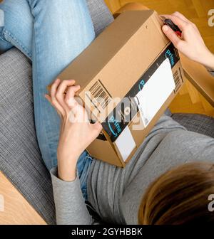 Vista dall'alto di una donna curiosa che guarda il nuovo Amazon prime Parcel Foto Stock