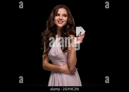 Giovane donna attraente che tiene la combinazione vincente di carte da poker Foto Stock