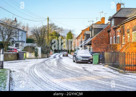 Scena del villaggio con una leggera copertura di neve di prima mattina. La prima mattina sole proprietà facciate. REGNO UNITO Foto Stock